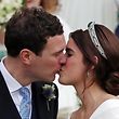 Britain's Princess Eugenie of York (R) and her husband Jack Brooksbank (L) kiss as they emerge from the West Door of St George's Chapel, Windsor Castle, in Windsor, on October 12, 2018 after their wedding ceremony. (Photo by Steve Parsons / POOL / AFP)