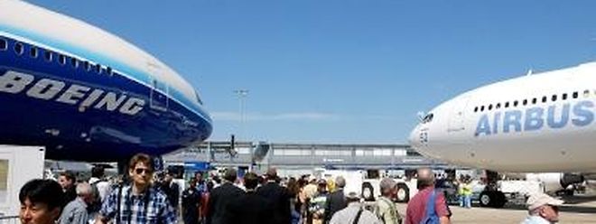 Streit um Subventionen: Besucher der Luftfahrtmesse in Le Bourget bei Paris gehen an einer Boeing 777 (l) und einem Airbus A340 vorbei (Archivbild)