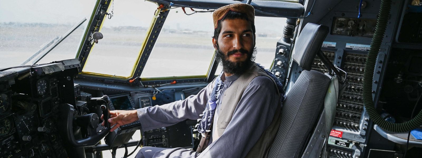 Um soldado talibã senta-se dentro do cockpit de um avião da Força Aérea Afegã no aeroporto de Cabul a 31 de agosto de 2021, depois de os EUA terem retirado todas as suas tropas do país 