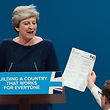 TOPSHOT - Protester comedian Simon Brodkin (R) gives a piece of paper written as a mock P45 (employee leaving form) to Britain's Prime Minister Theresa May (L) as she was delivering her speech on the final day of the Conservative Party annual conference at the Manchester Central Convention Centre in Manchester, northwest England, on October 4, 2017.
The protester interrupted the leader's speech to hand her a paper and then was escorted out of the auditorium. / AFP PHOTO / PAUL ELLIS