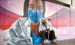 An elderly man sits behind a mural of a woman wearing a face mask in Acapulco, Guerrero state, Mexico, on May 6, 2020, amid the new coronavirus pandemic. - More than 15,000 people have been killed by the novel coronavirus in Latin America and the Caribbean as of 0230 GMT Wednesday, according to an AFP tally based on official reports. Topping the death toll list is Brazil, with 7,921 fatalities and 114,715 cases; followed by Mexico with 2,271 fatalities and Ecuador with 1,569 deaths. (Photo by FRANCISCO ROBLES / AFP)