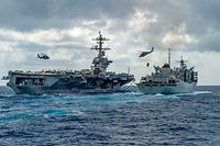 This handout picture released by the US Navy on May 8, 2019 shows the Nimitz-class aircraft carrier USS Abraham Lincoln (CVN 72) while conducting a replenishment-at-sea with the fast combat support ship USNS Arctic (T-AOE 9), while MH-60S Sea Hawk helicopters assigned to the "Nightdippers" of Helicopter Maritime Strike Squadron (HSM) 5, transfer stores between the ships. - The US is deploying an amphibious assault ship and a Patriot missile battery to bolster an aircraft carrier and B-52 bombers already sent to the Gulf, ratcheting up pressure on Iran. The USS Arlington, which transports marines, amphibious vehicles, conventional landing craft and rotary aircraft, and the Patriot air defence system will join the Abraham Lincoln carrier group, the Pentagon announced on May 10. (Photo by MCSN Jason Waite / Navy Office of Information / AFP)