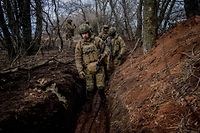 TOPSHOT - Ukrainian servicemen walk in a muddy trench near the frontline town of Bakhmut on March 2, 2023, amid the Russian invasion of Ukraine. (Photo by Dimitar DILKOFF / AFP)