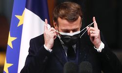French President Emmanuel Macron removes his protection mask prior his speech to the French frigate Bretagne during the New Year wishes to the military forces in Brest, on January 19, 2021. (Photo by STEPHANE MAHE / POOL / AFP)