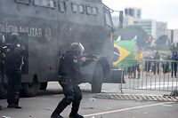 TOPSHOT - Security forces confront supporters of Brazilian former President Jair Bolsonaro invading Planalto Presidential Palace in Brasilia on January 8, 2023. - Hundreds of supporters of Brazil's far-right ex-president Jair Bolsonaro broke through police barricades and stormed into Congress, the presidential palace and the Supreme Court Sunday, in a dramatic protest against President Luiz Inacio Lula da Silva's inauguration last week. (Photo by Ton MOLINA / AFP)