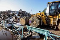This photograph taken on July 17, 2021 shows a bulldozer clearing rubble in a street following heavy rainfall that caused severe flooding in the area, in Chaudfontaine. - The death toll from flooding in eastern Belgium hit 24 on July 17, as police went door-to-door seeking news of at risk residents and the prime minister toured devastated towns. (Photo by Fran�ois WALSCHAERTS / AFP)