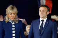 French President and La Republique en Marche (LREM) party candidate for re-election Emmanuel Macron (R) closes his eyes as he holds Brigitte Macron's hand while celebrating his victory in the second round of France's presidential election, at the Champ de Mars, in Paris, on April 24, 2022. (Photo by Ludovic MARIN / AFP)
