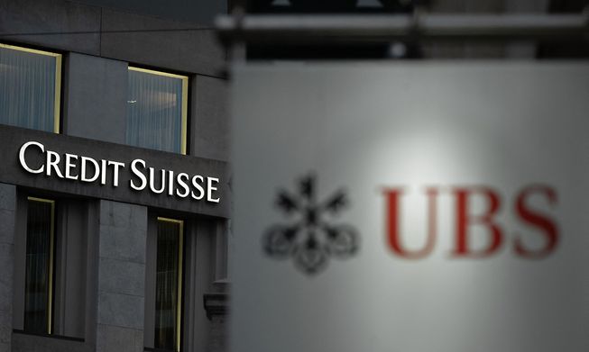 A sign of Credit Suisse bank, seen behind a sign of Swiss bank UBS, in Geneva
