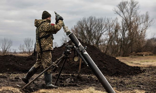 A Ukrainian serviceman inserts a shell into a mortar launcher, 30 December, 2022.