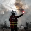 Top shot - Demonstrators wearing Confederation of French Trade Union (CGT) jackets wave light flares during a rally in Lyon, southeastern France, on January 19, 2023. Workers are on strike over the plans of the French president. Raise the legal retirement age from 62 to 64.  - A day of strikes and protests kicked off in France on January 19, with a government trial set to disrupt transport and schooling across the country as workers oppose a review of their very unpopular pensions. rice field.  (Photo by Olivier Chassignol/AFP)