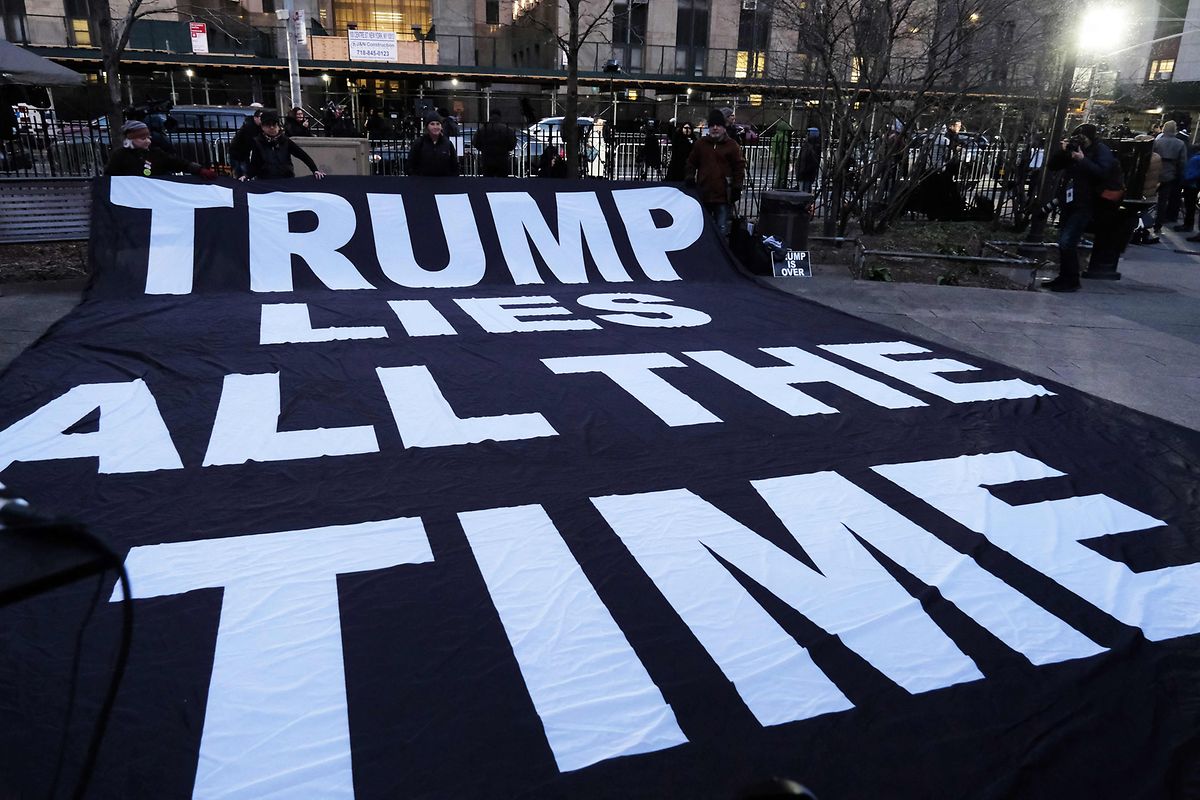Demonstranten rollen vor dem Gerichtsgebäude in New York ein Banner aus, auf dem in Englisch steht: "Trump lügt andauernd"