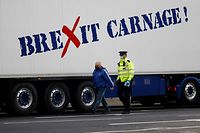 Police officers inspect the truck of a driver working in the shellfish industry who brought his truck to central London to protest against post-Brexit red tape and coronavirus restrictions, which they say could threaten the future of the industry, in London on January 18, 2021. (Photo by Tolga Akmen / AFP)