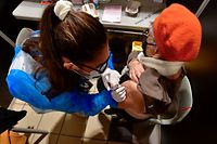 Patient receives a dose of vaccine at the Toulouse's exhibition centre used as a vaccination centre in Toulouse, on December 9, 2021. - After several weeks of closure, the vaccination centre is back in service on December 9, 2021. (Photo by GEORGES GOBET / AFP)
