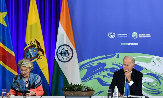 US President Joe Biden (R) reacts as he listens to European Commission President Ursula von der Leyen (L) during the COP26 UN Climate Change Conference in Glasgow, Scotland, on Tuesday