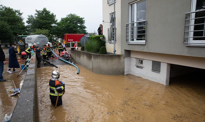 Emergency services pump water from an apartment block garage where four people were trapped