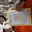 Ein niederländische Helfer mit einer in den Trümmerbergen von Port-au-Prince gefundenen Kinderzeichnung.