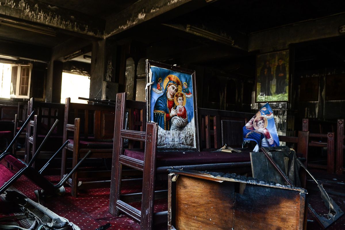 Zerstörte religiöse Bilder stehen auf einer Holzbank in der koptischen Abu-Sefein-Kirche in Giseh, die einem Großbrand zum Opfer gefallen ist.