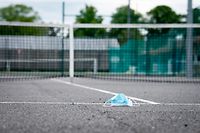 Eine Wegwerfschutzmaske liegt auf einem gesperrten Tennisplatz/ Sport, 2020 / 03.05.2020 /Sportplaetze während der Corona-Zeit / TC Lorentzweiler, Lorentzweiler /Foto: Ben Majerus