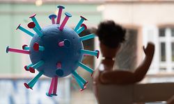 ARCHIV - 07.06.2021, Hessen, Frankfurt/Main: Ein stilisiertes Corona-Virus hängt in einem Schaufenster. Im Vordergrund ist eine Puppe zu sehen (zu dpa: «Inzidenz steigt kontinuierlich - Kommunen müssen Regeln verschärfen»). Foto: Sebastian Gollnow/dpa +++ dpa-Bildfunk +++