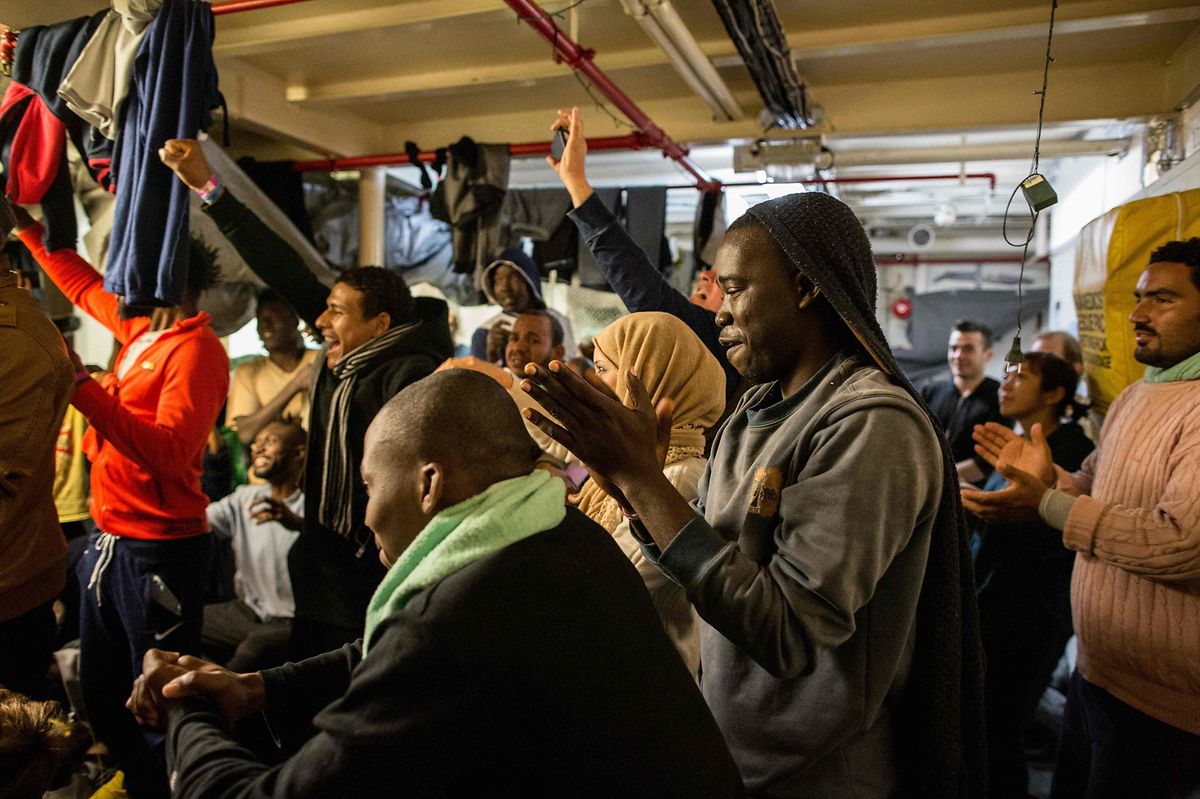 Migrants aboard the Dutch-flagged rescue Vessel "Sea Watch 3" sailing off Malta's coast, react o 9 January after it was announced that Malta has reached a deal with other EU member states to allow migrants onboard to disembark Photo: AFP