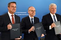 Luc Frieden (ao centro), formador do Governo e futuro primeiro-ministro, ladeado por Xavier Bettel (à esquerda), em representação do DP, e Claude Wiseler, em representação do CSV.