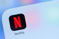(FILES) In this file photo taken on July 10, 2019, the Netflix logo is seen on a phone in this photo illustration in Washington, DC. - Netflix shares plunged more than 10 percent in after-hours trade on July 17, 2019, after its quarterly update showed weaker-than-expected subscriber growth for the streaming television sector leader. Netflix said it added 2.7 million new subscribers worldwide in the April-June period, well below expectations, as the sector prepared for offerings from rival groups including Walt Disney, Apple and others. (Photo by Alastair Pike / AFP)