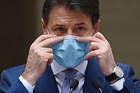 Italy's Prime Minister Giuseppe Conte, touches his protective facemask as he speaks during a press conference for the newly adopted measures to fight against the spread of th Covid-19, in the courtyard of the Chigi Palace, in Rome, on October 25, 2020, as teh country faces a second wave of infections to the Covid-19 (the novel coronavirus). - Italy's Prime Minister Giuseppe Conte tightened nationwide coronavirus restrictions on October 25, 2020 after the country registered a record number of new cases, despite opposition from regional heads and street protests over curfews. Cinemas, theatres, gyms and swimming pools must all close under the new rules, which come into force on Monday and run until November 24, while restaurants and bars will stop serving at 6pm, the prime minister's office said. (Photo by Vincenzo PINTO / AFP)