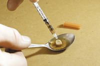 Drogensuechtiger beim Aufziehen einer Spritze