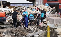 20.07.2021, Nordrhein-Westfalen, Bad Münstereifel: Menschen räumen in Bad Münstereifel Schutt beiseite. Bundeskanzlerin Merkel und Nordrhein-Westfalens Ministerpräsident Laschet haben das vom Unwetter stark betroffene Bad Münstereifel besucht. Foto: Oliver Berg/dpa - ACHTUNG: Verwendung nur im vollen Format +++ dpa-Bildfunk +++