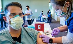 18.12.2020, USA, Redlands: Krankenpfleger Joe Robertson sitzt auf einem Stuhl, während er von einer Mitarbeiterin mit dem Corona-Impfstoff von Pfizer-BioNTech im «Stan and Ellen Weisser Education Pavilion» im Krankenhaus «Redlands Community Hospital» geimpft wird. Er war einer von mehr als 60 Mitarbeitern des Krankenhauses, die als erstes geimpft wurden. Foto: Terry Pierson/Orange County Register via ZUMA/dpa +++ dpa-Bildfunk +++