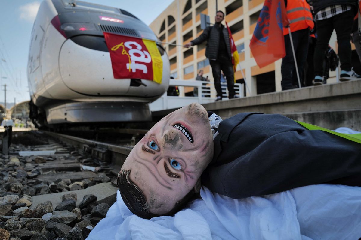 Protestors lay an effigy of French President Emmanuel Macron on a railway track during a demonstration at Nice's railway station, south-eastern France, on 22 March, 2023