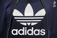 ARCHIV - 08.03.2017, Bayern, Herzogenaurach: Ein Logo des Sportartikelherstellers Adidas ist während der Bilanz-Pressekonferenz des Unternehmens auf einem Kleidungsstück zu sehen. Am 27.04.2020 werden die Zahlen für das 1. Quartal veröffentlicht. Foto: Daniel Karmann/dpa +++ dpa-Bildfunk +++