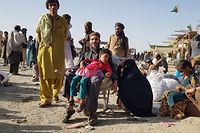TOPSHOT - Stranded people wait for the reopening of the Pakistan-Afghanistan border crossing point which was closed by the authorities, in Chaman on August 12, 2021, after the Taliban took control of the Afghan border town in a rapid offensive across the country. (Photo by STRINGER / AFP)