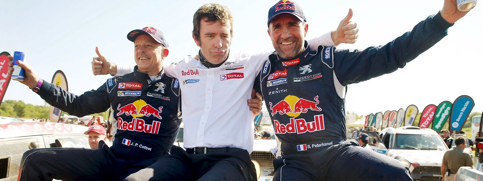 Stephane Peterhansel (dta.), com o co-piloto Jean Paul Cottret, à esquerda, e o director da Peugeot, Bruno Famin, ao centro, celebram a vitória