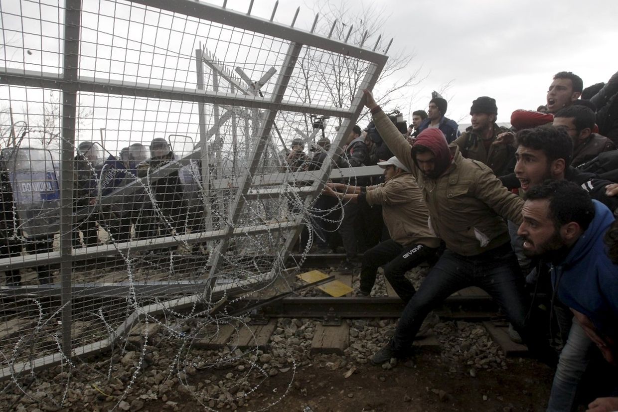 Gestrandete Flüchtlinge versuchen, einen Grenzzaun zwischen Mazedonien und Griechenland einzureißen. 