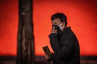 A man re-adjusts his protective mask near Tiananmen Gate in Beijing on January 23, 2020. - China is halting public transport and closing highway toll stations in two more cities in Hubei province, the epicentre of a deadly virus outbreak, authorities said on January 23. (Photo by NICOLAS ASFOURI / AFP)