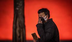 A man re-adjusts his protective mask near Tiananmen Gate in Beijing on January 23, 2020. - China is halting public transport and closing highway toll stations in two more cities in Hubei province, the epicentre of a deadly virus outbreak, authorities said on January 23. (Photo by NICOLAS ASFOURI / AFP)