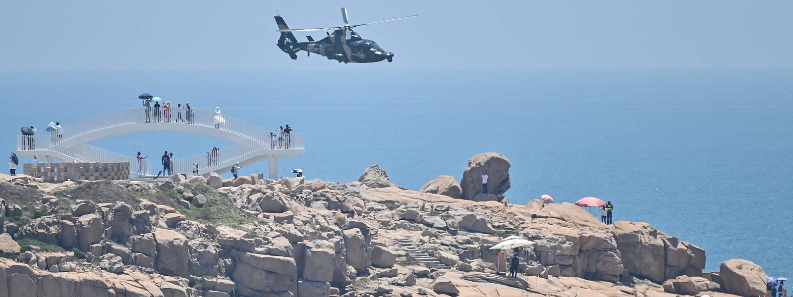 Des touristes assistent au survol des plages taïwanaises par les hélicoptères chinois.