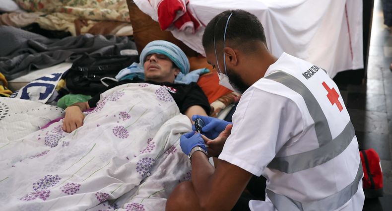 A medic tends to a hunger-striking immigrant worker in the Beguinage church in Brussels on July 19, 2021. - Over 400 undocumented workers, mainly from Morocco and Algeria, are staging a mass hunger strike in Belgium to pressure authorities into granting them the right to remain in the country. The strikers have been camped out for six weeks at several locations in the capital Brussels, including in a church and a university canteen, and academics are calling for an urgent solution as fears over their health grow. (Photo by Fran�ois WALSCHAERTS / AFP)