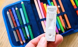 ILLUSTRATION - 08.04.2021, Niedersachsen, Hannover: Ein Corona-Selbsttest, fotografiert mit neben dem Etui eines Grundschülers. In zahlreichen Bundesländern geht der Unterricht nach den Osterferien mit einer Corona-Testpflicht weiter. Ohne negatives Testergebnis ist der Besuch des Unterrichts nicht möglich. Foto: Julian Stratenschulte/dpa +++ dpa-Bildfunk +++