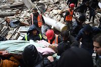 TOPSHOT - Syrian civil defence members carry an injured woman after rescuing her from the rubble of a collapsed building after an earthquake in the government-controlled Aleppo on February 6, 2023. - A 7.8-magnitude earthquake hit Turkey and Syria early on February 6, killing hundreds of people as they slept, levelling buildings and sending tremors that were felt as far away as the island of Cyprus, Egypt and Iraq. (Photo by AFP)