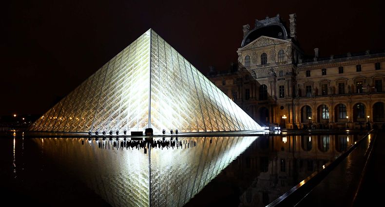 (FILES) In this file photo taken on October 02, 2018, the Louvre Pyramid is illuminated in the night, prior to the Louis Vuitton Spring-Summer 2019 Ready-to-Wear collection fashion show in Paris. - The world's most popular museum, the Paris Louvre, received over 10 million visitors in 2018, a record which it partly attributed Thursday to a Beyonce video shot against the backdrop of the Mona Lisa and other famous works. (Photo by Bertrand GUAY / AFP)