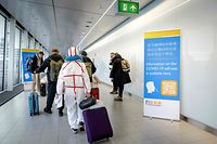Travelers arriving China walk past information banners and receive free Covid-19 self-test kits, at Amsterdam's Schiphol Airport on January 4, 2023. - More than a dozen countries have imposed coronavirus testing requirements on visitors from China, which is experiencing an explosion of cases after lifting its long-standing zero-Covid measures. (Photo by Robin van Lonkhuijsen / ANP / AFP) / Netherlands OUT