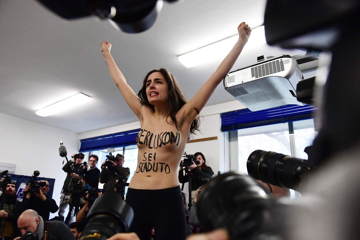 "Berlusconi, du bist abgelaufen" hat sich die Frau als Protest auf ihren Körper geschrieben.