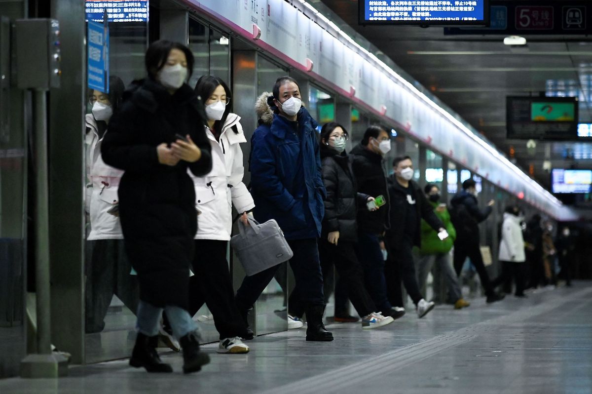 Commuters step out of a train at a subway station in Beijing on 17 January, 2023