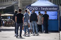 People queue at a Covid test center installed in a street of Swiss capital Bern on September 17, 2021. - People who have not been vaccinated and have not recovered from the coronavirus will have to present a negative Covid test to enter Switzerland from September 20, 2021. The Swiss government wants to avoid an increase of cases after the autumn holidays, it said. (Photo by Fabrice COFFRINI / AFP)