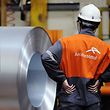 Employees looking at galvanized steel coils are stored at ArcelorMittal's, the world's largest steel maker. 