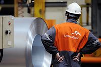 An employee looks at coils of steel treated by galvanization are stored in the world's largest steel maker ArcelorMittal's "cold factory" of the northeastern France plant of Florange, on April 16, 2013. Usibor steel (weight savings and improved crashworthiness) are producted in the cold factory.   AFP PHOTO / JEAN-CHRISTOPHE VERHAEGEN
