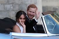 Britain's Prince Harry, Duke of Sussex, (R) and Meghan Markle, Duchess of Sussex, (L) leave Windsor Castle in Windsor on May 19, 2018 in an E-Type Jaguar after their wedding to attend an evening reception at Frogmore House.  / AFP PHOTO / POOL / Steve Parsons