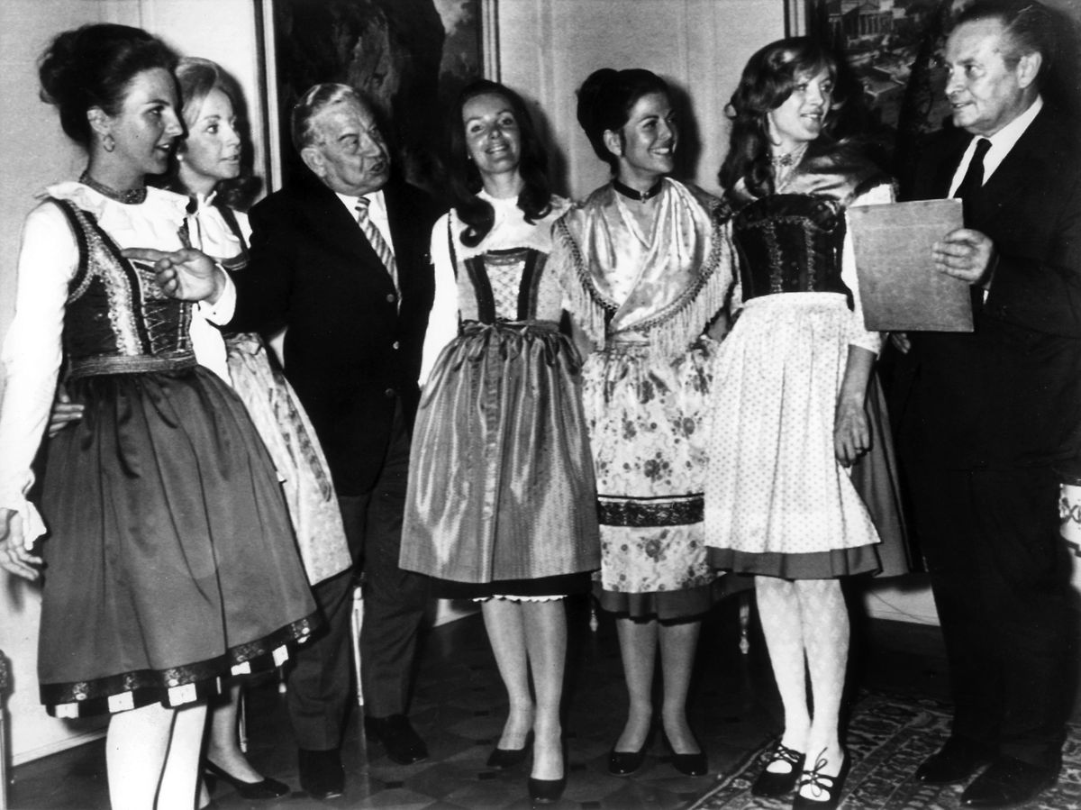 Die spätere Königin Silvia von Schweden (3.v.r.) zeigt gemeinsam mit anderen Hostessen dem bayerischen Ministerpräsidenten Alfons Goppel (l) und dem deutschen NOK-Präsident Willi Daume (r) in München die bayerischen Trachten in denen die Mädchen bei den Olympischen Spielen 1972 in München die Medaillen überreichen werden.
